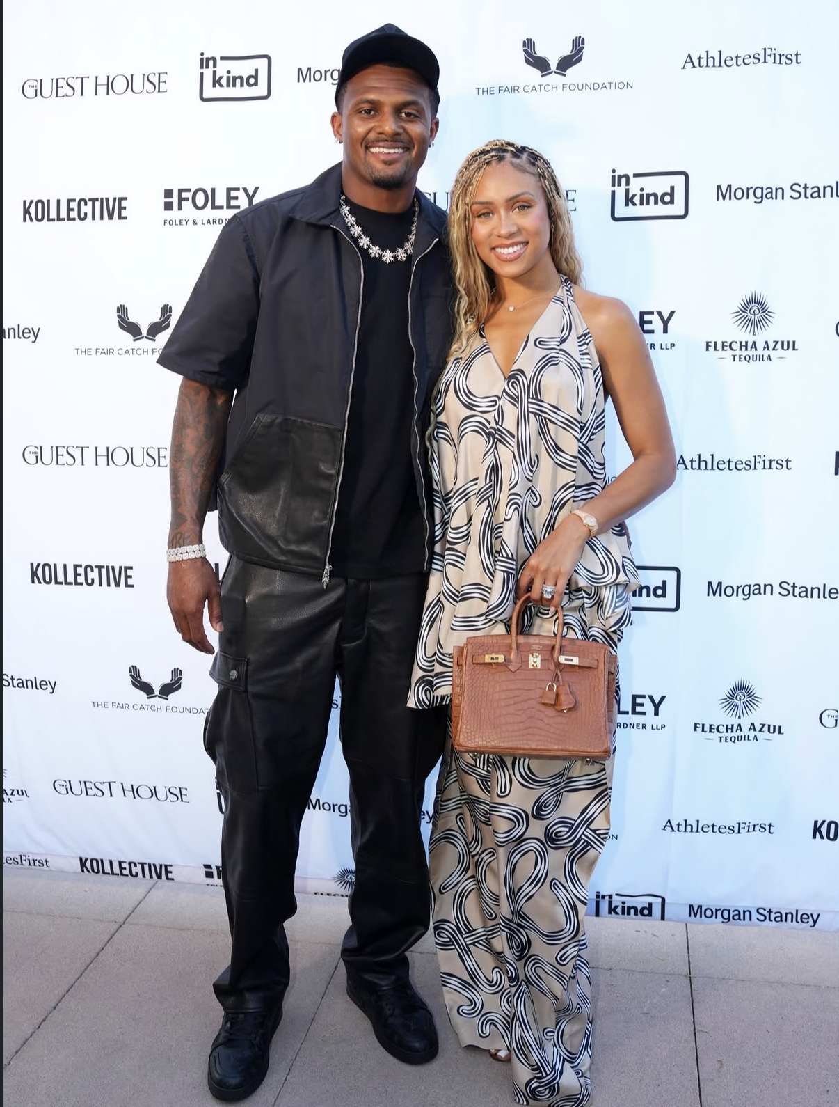 Deshaun Watson and a guest pose together on the red carpet at the 2026 event.
