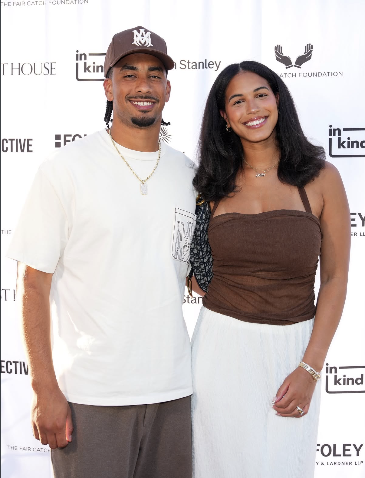 A couple smiles for a portrait on the step-and-repeat at the 2026 event.