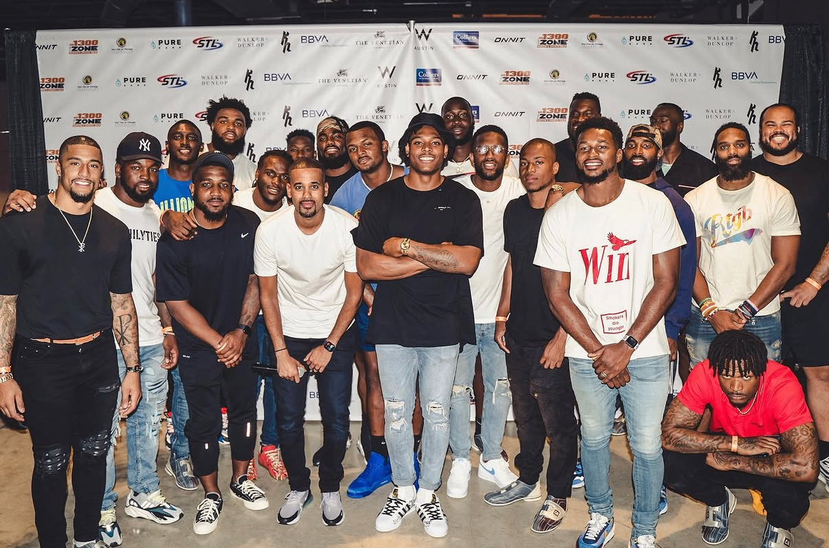 A full group of NFL players gathers for a team photo on the event backdrop at the 2019 Bowl with the Pros Charity Event.