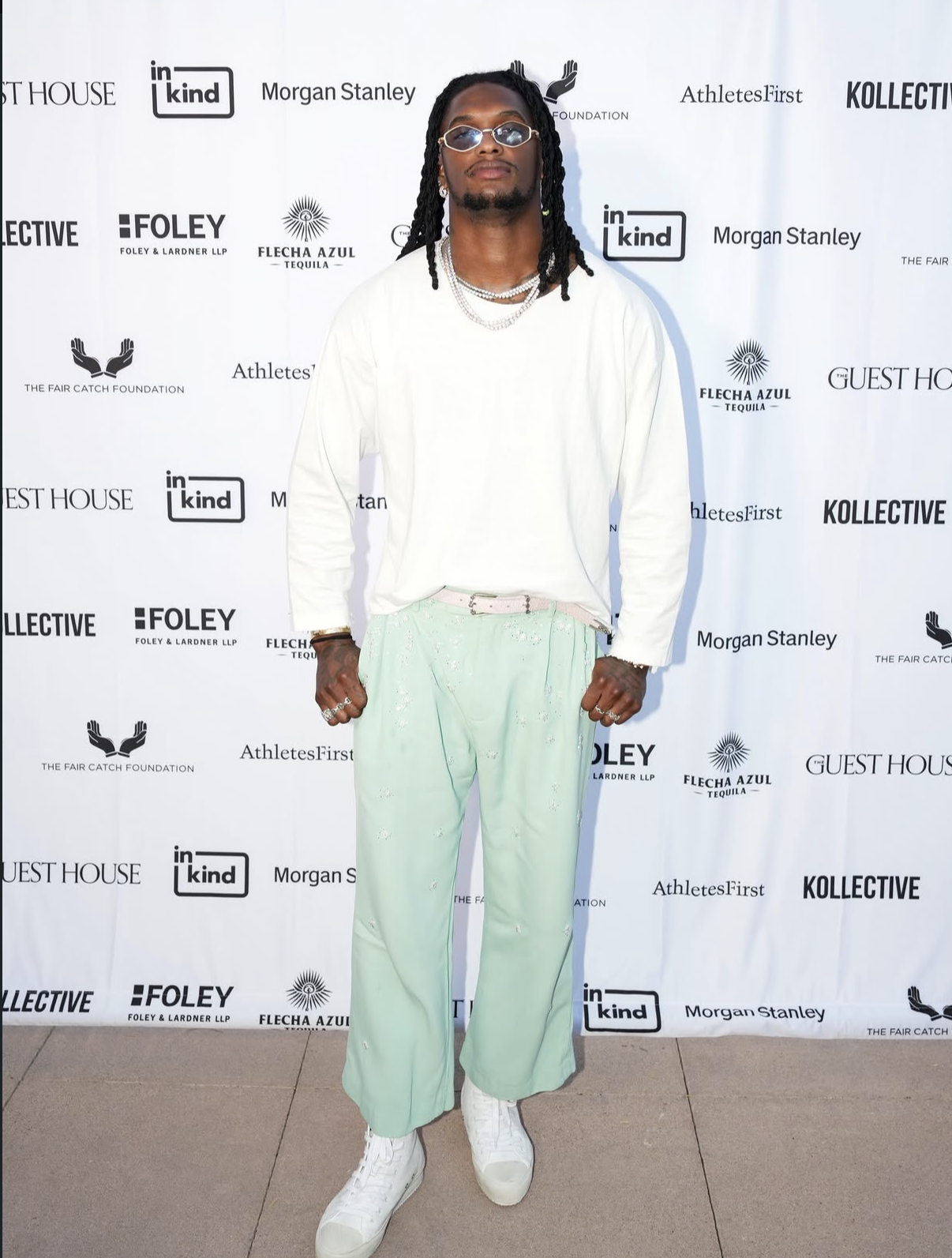 A stylish guest in a white top and mint trousers on the 2025 red carpet.