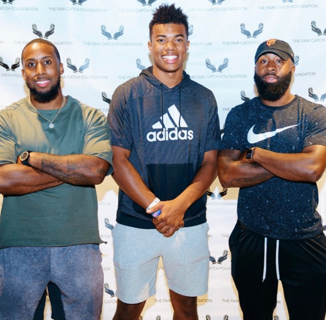 Three NFL players stand together in front of the Fair Catch Foundation backdrop at the 2018 Bowl with the Pros Charity Event.