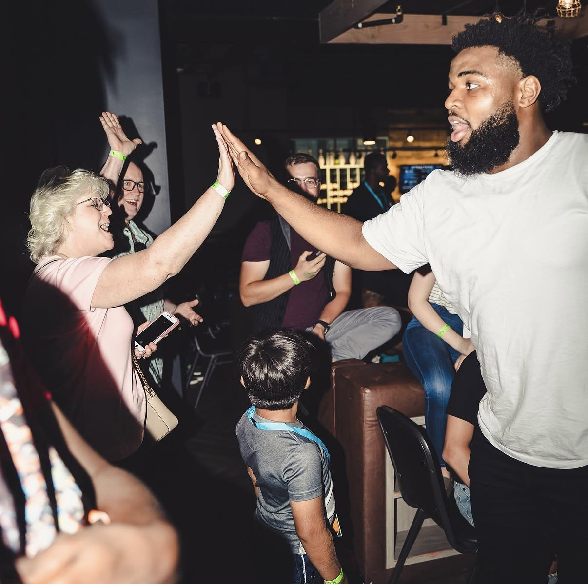 An NFL player high-fives a cheering guest during the 2018 Bowl with the Pros Charity Event.