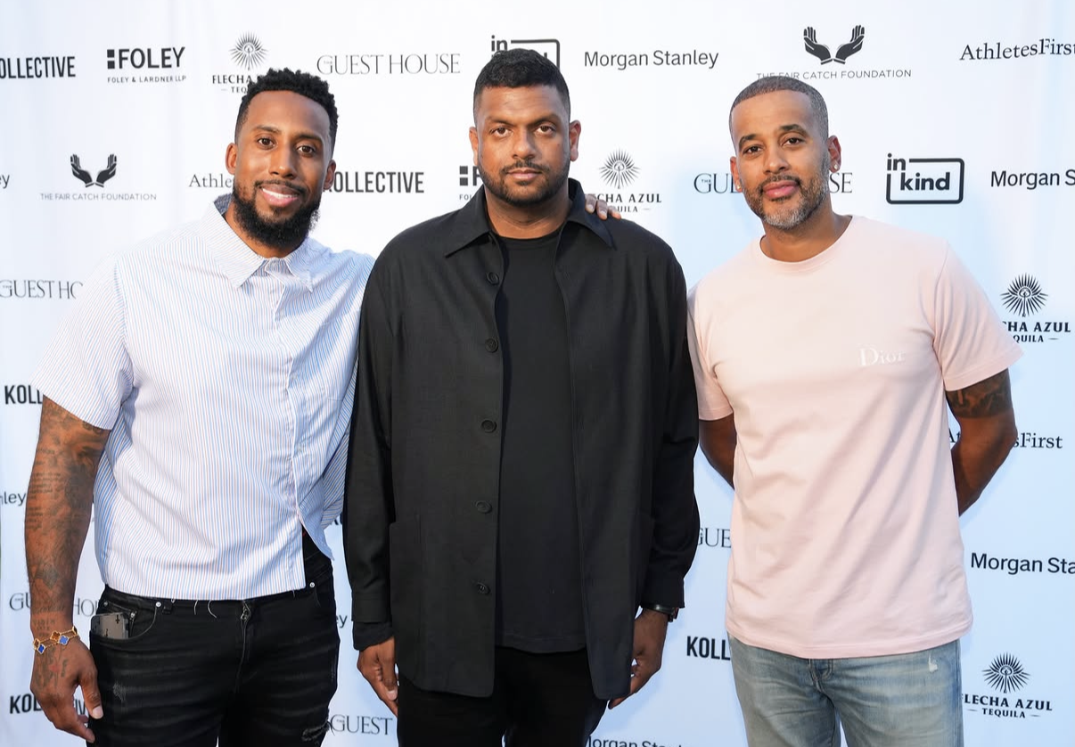 Three co-hosts pose together on the step-and-repeat at the 2026 event.