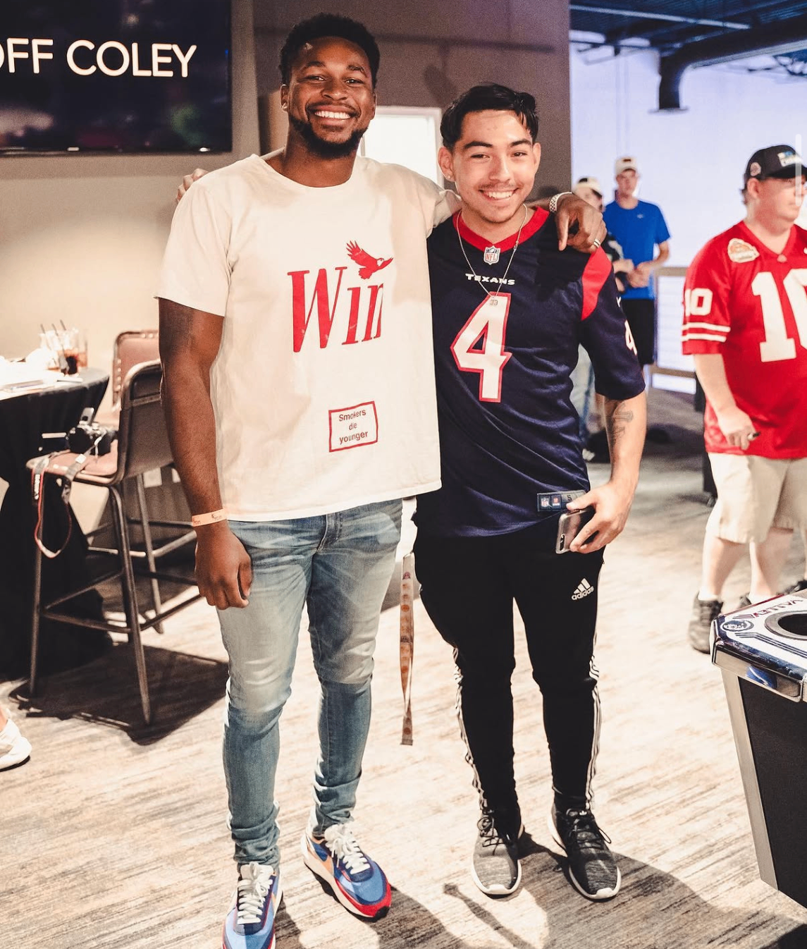 An NFL player and a young Texans fan pose together on the event floor at the 2019 Bowl with the Pros Charity Event.