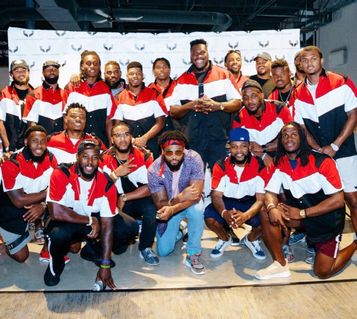A celebrity player mid-throw releases a red bowling ball down the lane at the 2018 Bowl with the Pros Charity Event.