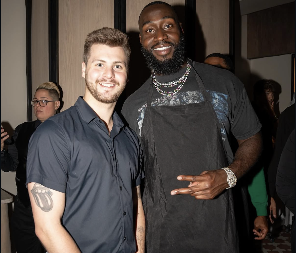 Guest poses with a celebrity waiter wearing an apron during the 2024 event.