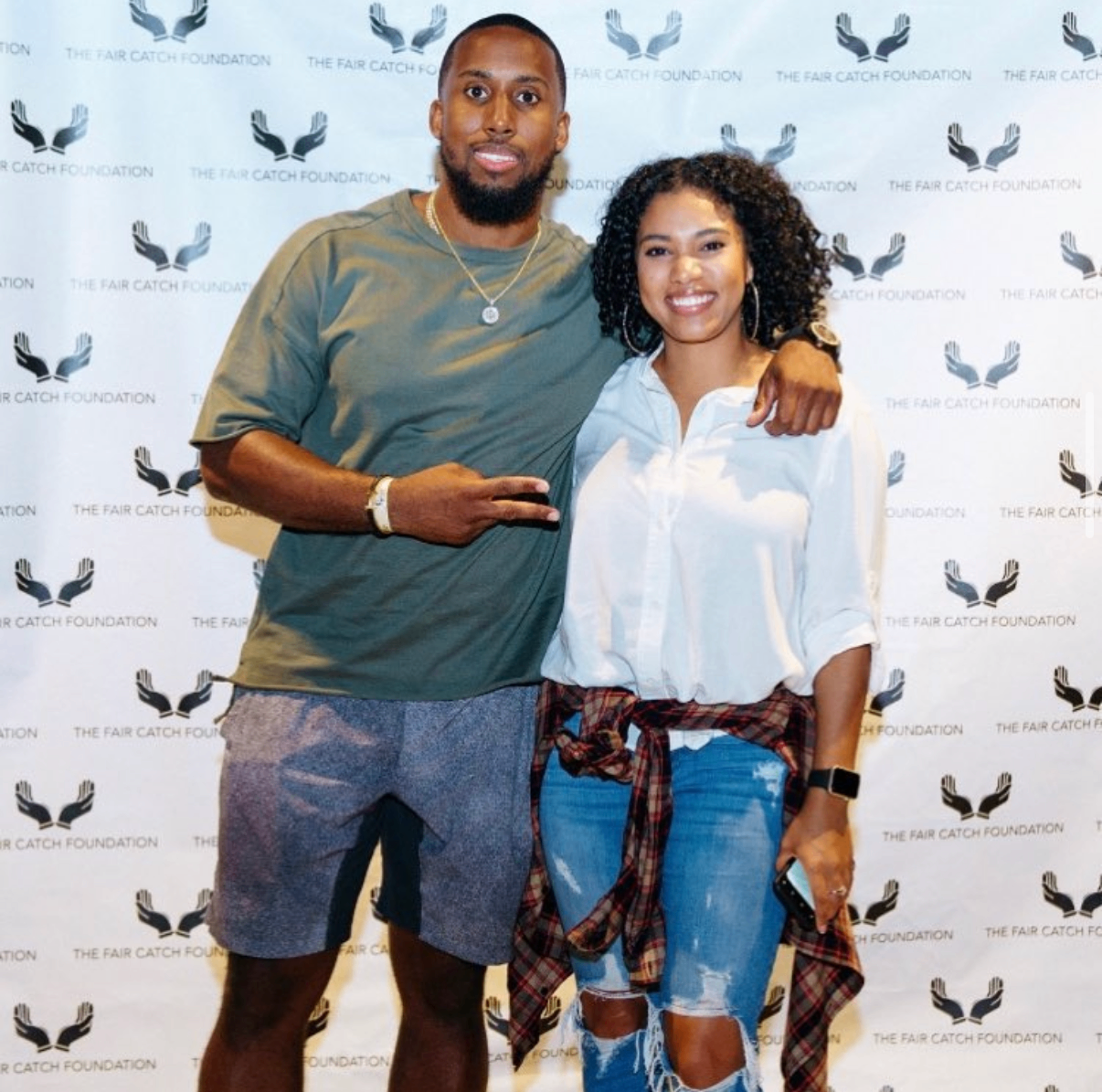 An NFL player poses with a fan in front of the Fair Catch Foundation backdrop at the 2018 Bowl with the Pros Charity Event.