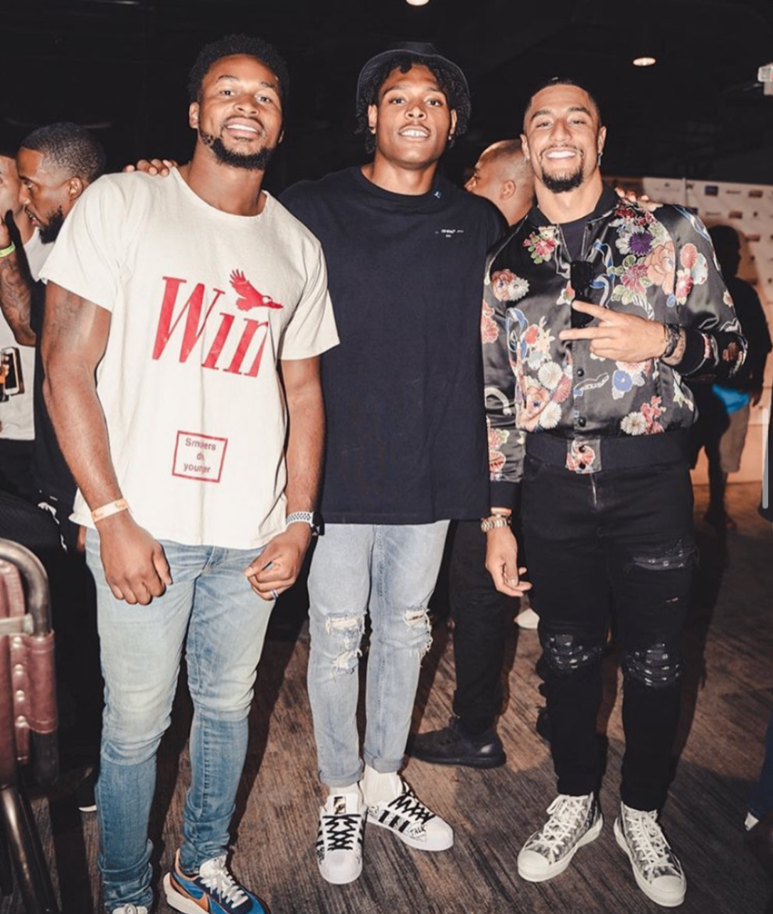Three celebrity players pose together on the event floor at the 2019 Bowl with the Pros Charity Event.