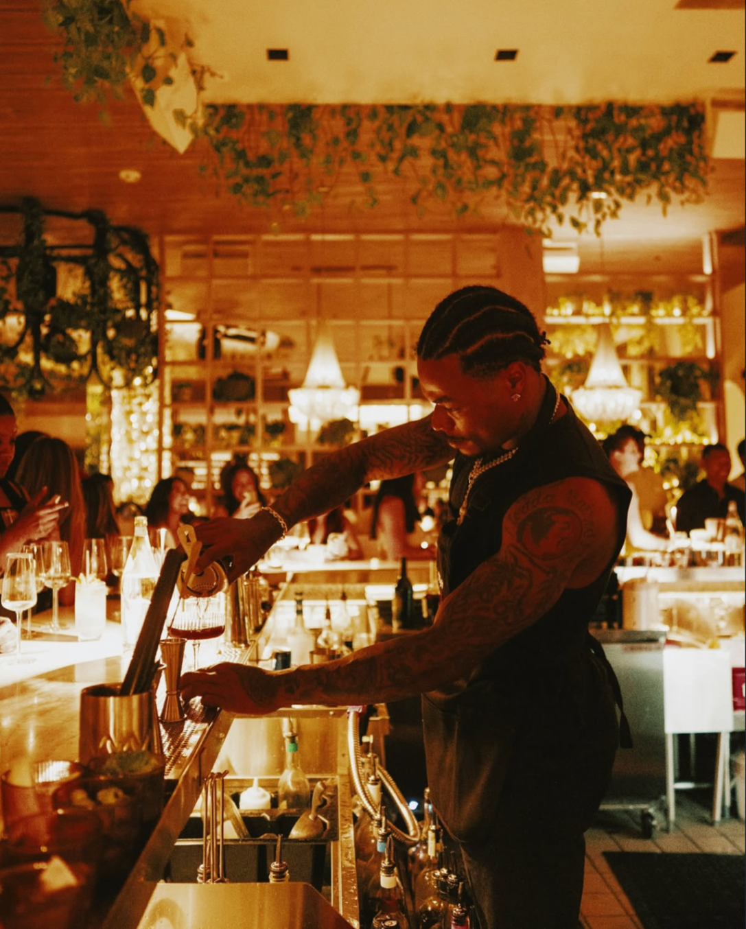 A celebrity guest bartender pours a drink during the 2025 Celebrity Waiter Night.