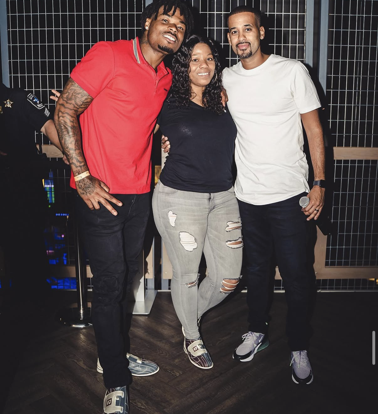 A celebrity player, guest, and host pose together for a photo at the 2019 Bowl with the Pros Charity Event.