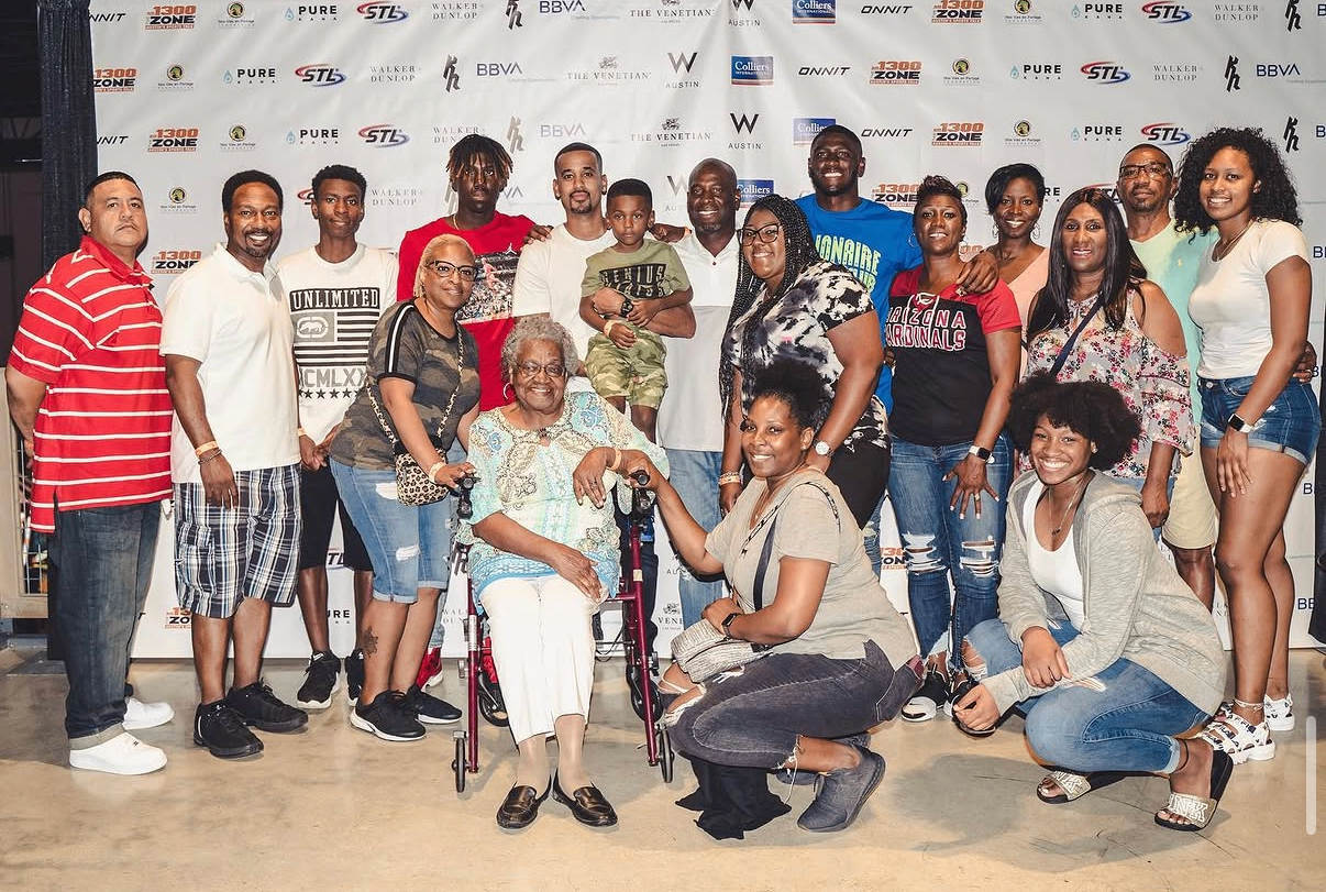 A large family group poses together on the step-and-repeat at the 2019 Bowl with the Pros Charity Event.