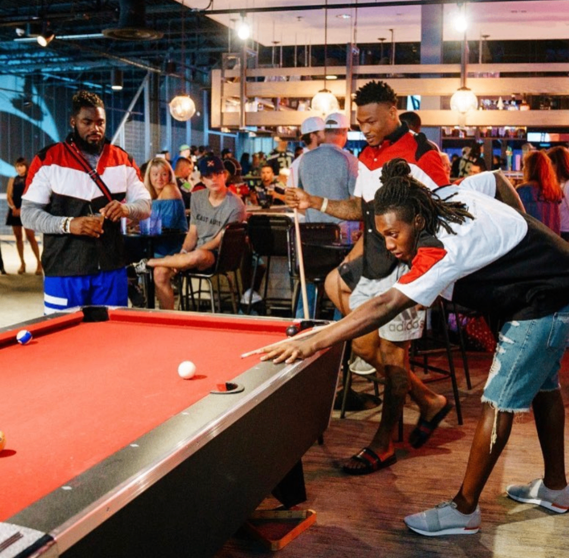 A guest wearing a Watson jersey bowls down a neon-lit lane at the 2018 Bowl with the Pros Charity Event.