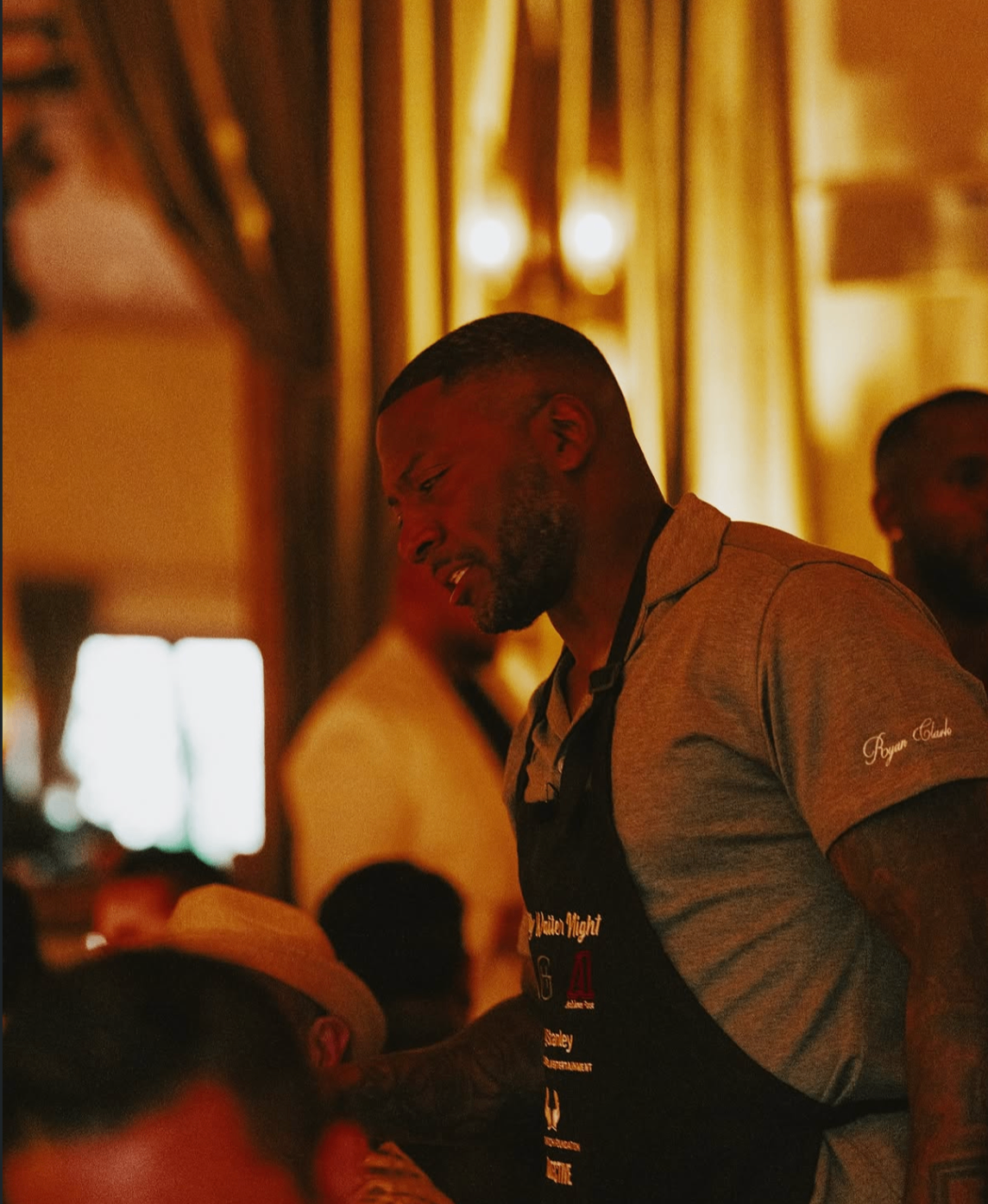 A celebrity waiter greets guests tableside during the 2025 event.