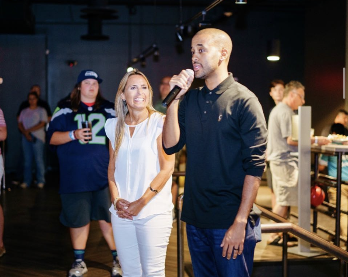 A family and celebrity guest pose together in football jerseys at the 2018 Bowl with the Pros Charity Event.