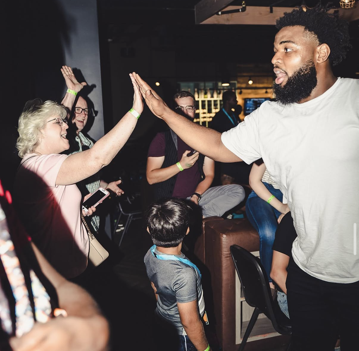 A celebrity player shares a high-five with an excited guest during the 2019 Bowl with the Pros Charity Event.